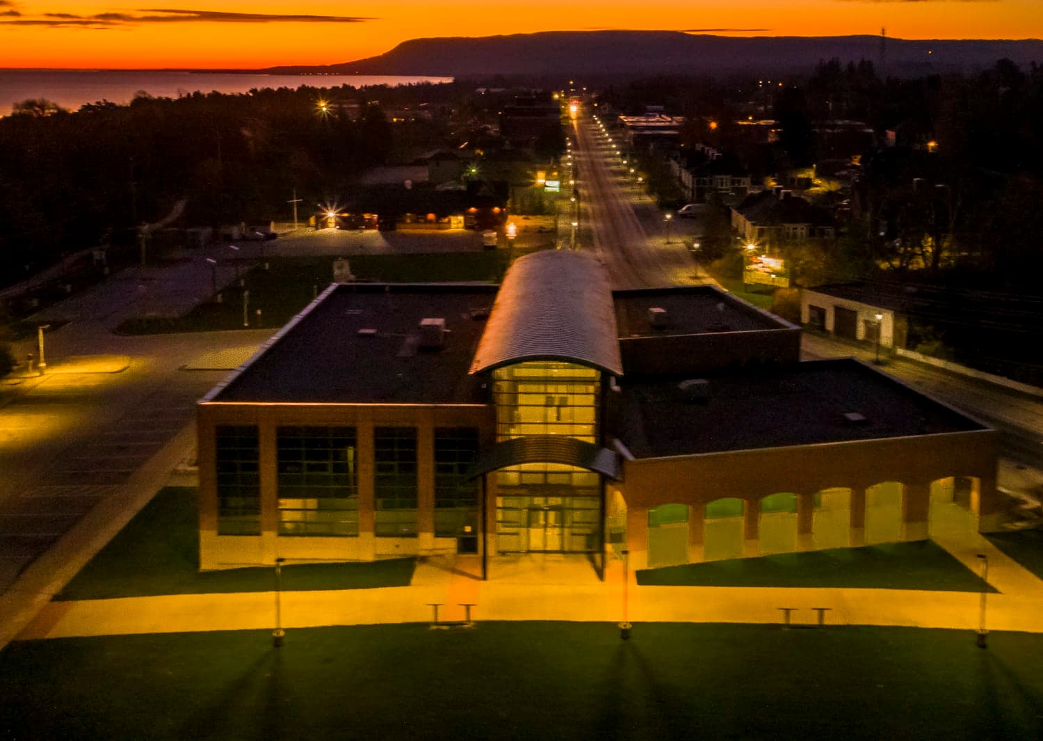 Town hall lit at dusk with the escarpment and shoreline beyond