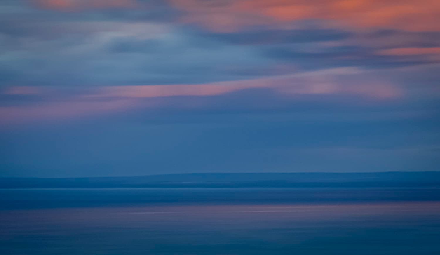 Abstract long-exposure study of sky and water at dusk