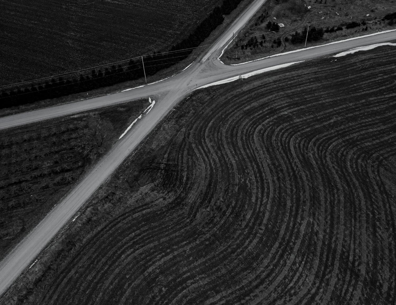Black and white abstract of a farm field and crossroads from above