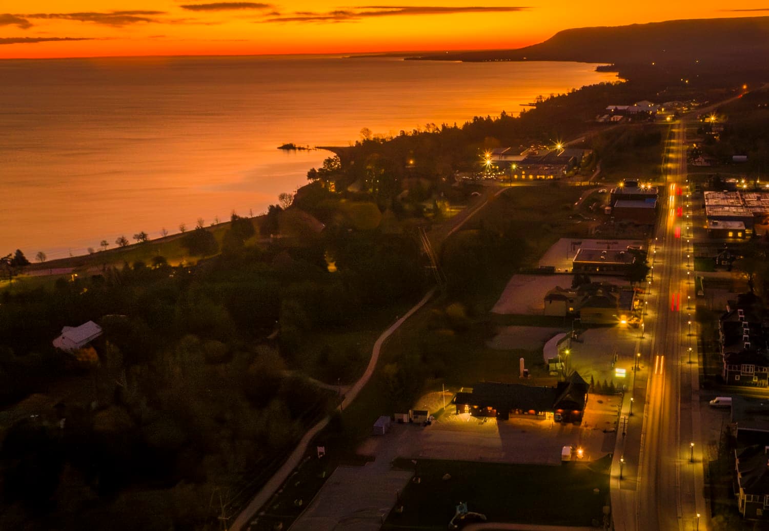 Shoreline road at dusk with the bay stretching to the horizon