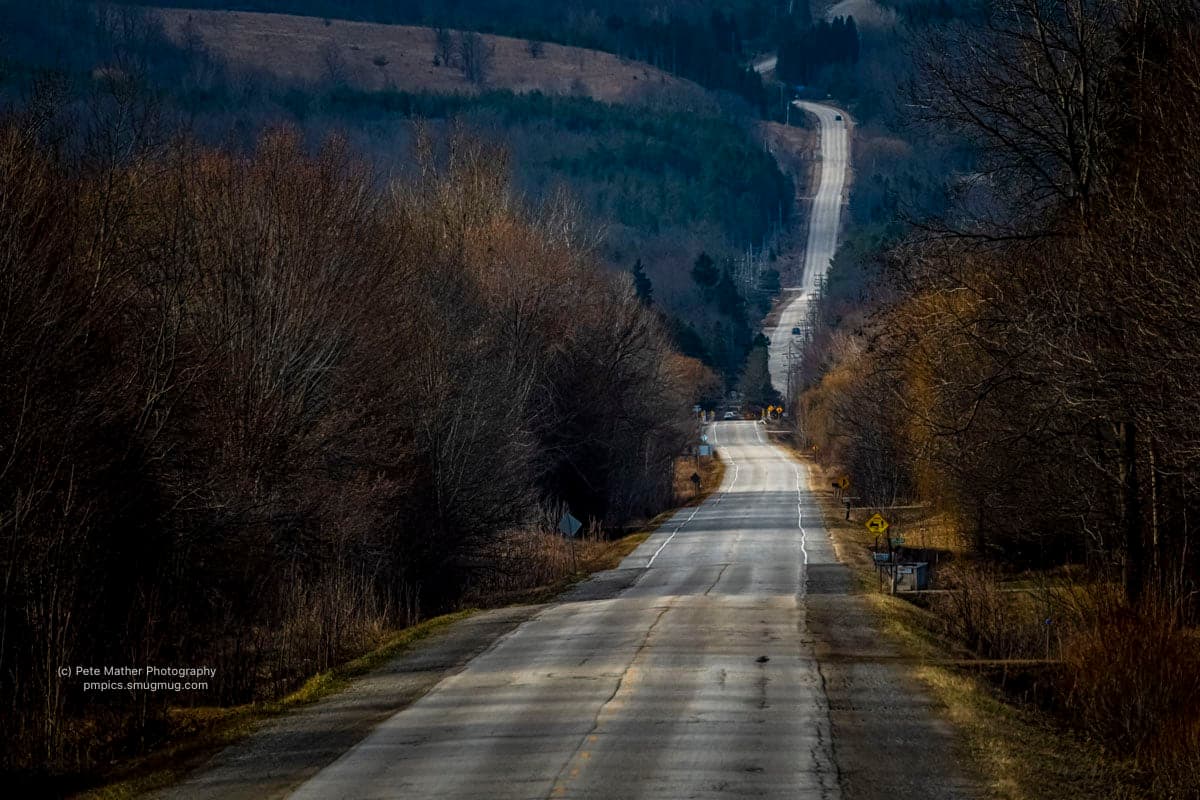Country road running straight toward the escarpment