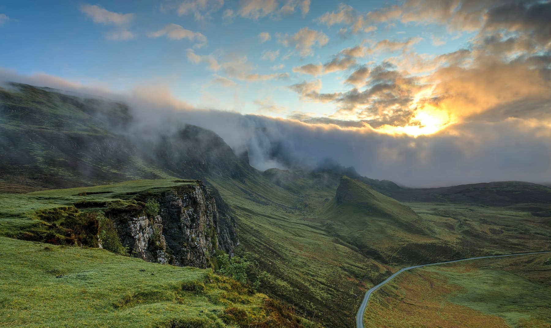 Fog lifting off wooded hills at dawn